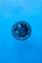 Drinking water with ice in transparent blue glass on blue background. Top view, selective focus, copy space Royalty Free Stock Photo