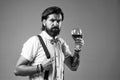 drinking wine glass. bearded man in suspenders drink red wine. elegant businessman wear bow tie for formal event Royalty Free Stock Photo