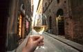 Drinking wine on street. Hand of a happy drinker in outdoor cafe of narrow historical area, enjoying alone Royalty Free Stock Photo