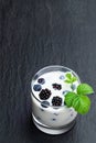 Drinking yogurt with fresh berries in a glass on black stone background Royalty Free Stock Photo