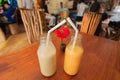 Drinks for lovers. Two bottles of sweet fruit smoothies, on the table of a popular cafe. Concept of healthy dates