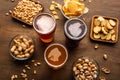 Dark, light, unfiltered beer in glasses and crispy appetizers in plates on wooden table