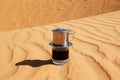 Drip Black Coffee in Vietnamese style with condensed milk on a red sand with copy space. Royalty Free Stock Photo