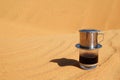 Drip Black Coffee in Vietnamese style with condensed milk on a red sand with copy space. Traditional method of making coffee. Royalty Free Stock Photo