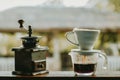 Drip brewing coffee with smoke and coffee grinder on wooden bar in morning