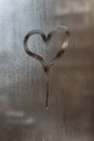 Drip in the shape of a heart on a misted window-glass. Close-up. Background