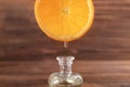 Dripping citrus essential oil into bottle on blurred background