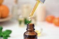 Dripping citrus essential oil into bottle, closeup