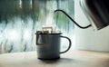 Dripping Coffee by the Window on Morning Rainy Day. Making Hot Drink by Pouring Hot Water from kettle into an Instant Coffee Drip Royalty Free Stock Photo