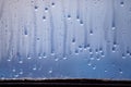 Dripping drops of condensed water on the glass. Background of natural water pooling from window condensation Royalty Free Stock Photo