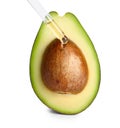 Dripping essential oil onto cut avocado on white background Royalty Free Stock Photo