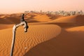 Dripping faucet, desert and skyline of big city in the background