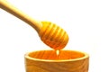 Dripping honey on wooden dipper or wooden spoon isolated on whit Royalty Free Stock Photo