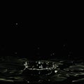 Dripping liquid, formed a dark crater and water splashes. Royalty Free Stock Photo