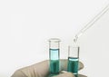 Dripping reagent into test tube with liquid sample