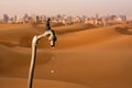 Dripping tap, desert and skyline of big city in the background Royalty Free Stock Photo