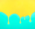 Dripping yellow paint on turquoise blue background Royalty Free Stock Photo