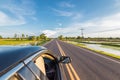Drive car on the road near the field under blue sky. Royalty Free Stock Photo