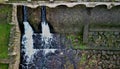 drive of the mill under bridge. water is filtered through sieve grid so that Royalty Free Stock Photo