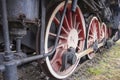 Drive transmission mechanism in a historic and damaged steam locomotive standing on a sidetrack. Rail