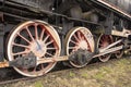 Drive transmission mechanism in a historic and damaged steam locomotive standing on a sidetrack. Rail
