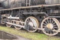 Drive transmission mechanism in a historic and damaged steam locomotive standing on a sidetrack. Rail