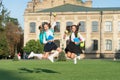 Driven and energetic. Energetic children in midair outdoors. School girls in energetic jump. Back to school fashion