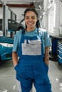 Driven to serve better. Portrait of young african american woman, professional female mechanic in uniform smiling at