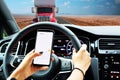 Driver browsing smartphone while on the road increasing the risk of an accident Royalty Free Stock Photo