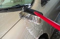 Driver at the car wash washes the car with a brush. Washing vehicle with foam at self car wash service outdoors Royalty Free Stock Photo