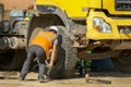 Driver changes the blown wheel on the construction site