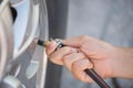 Driver checking air pressure and filling air in the tires Royalty Free Stock Photo