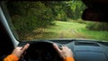 Driver driving a modern off road left hand drive LHD car on the mountain green forest country road. Face reflecting in inside Royalty Free Stock Photo