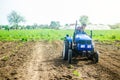 A driver on a farm tractor performs land work on the field. Loosening surface, cultivation. Farming, agriculture. Plowing field. Royalty Free Stock Photo