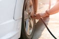 Driver filling air into a car tire, tire inflation Royalty Free Stock Photo