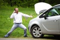 Driver furious with mobile phone a broken car Royalty Free Stock Photo