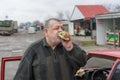 Driver gobbling lyulya kebab in lavash near his car Royalty Free Stock Photo