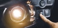 Driver hand adjusting headlight level switch and car headlight bright Royalty Free Stock Photo