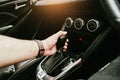 Driver hand holding gear lever of automatic transmission and hand moves the gear lever in the car Royalty Free Stock Photo
