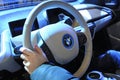 Driver hand holding steering wheel of a modern electric car BMW.