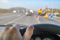 Driver hand on the steering wheel of a car against the background of road works Royalty Free Stock Photo