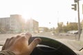 Driver hand on the steering wheel of a car that is blinded by bright sunlight Royalty Free Stock Photo