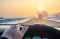 Driver hand on the steering wheel of a car that is driving in the flow of traffic on a country highway, freeway Royalty Free Stock Photo