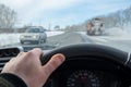 Driver hand is on the steering wheel inside the car, which is driving on a slippery highway Royalty Free Stock Photo
