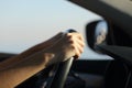 Driver hands holding steering wheel driving a car