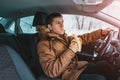 Driver has a sharp drop in blood sugar and he urgently eats a banana while driving through the streets in winter. The concept