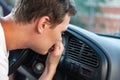 The driver held his nose from the bad smell , air conditioner heating, the concept of faulty air conditioners, bad smell and car,