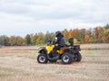 Driver in helmet on yellow quad bike on field