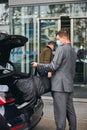 Driver helping his passenger with his luggage Royalty Free Stock Photo