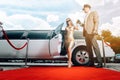 Driver helping VIP woman or star out of limo on red carpet Royalty Free Stock Photo